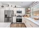Bright eat-in kitchen with stainless steel appliances, white cabinets, quartz countertops, and large window at 25324 Lexington Oaks Blvd, Wesley Chapel, FL 33544