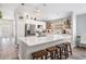 Bright kitchen with stainless steel appliances, white cabinets, quartz countertops, barstool seating at the island, and open floorplan at 25324 Lexington Oaks Blvd, Wesley Chapel, FL 33544