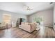 Bright living room featuring wood-look floors, a comfortable couch, and sliding glass doors to the pool at 25324 Lexington Oaks Blvd, Wesley Chapel, FL 33544