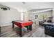 Spacious living room featuring a pool table, foosball table, leather couch, and an arcade game at 25324 Lexington Oaks Blvd, Wesley Chapel, FL 33544
