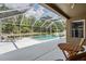Screened-in pool featuring an in-ground pool, patio furniture, and view of wooded area at 25324 Lexington Oaks Blvd, Wesley Chapel, FL 33544