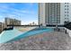 View of the community basketball court and outdoor seating areas in front of a high-rise condominium building at 2910 W Barcelona St # 1902, Tampa, FL 33629