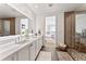 Bright bathroom with dual sinks, large mirror, glass shower and bedroom access at 2910 W Barcelona St # 1902, Tampa, FL 33629