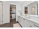 Modern bathroom with double sinks, large mirror, and walk-in closet with shelving at 2910 W Barcelona St # 1902, Tampa, FL 33629