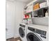 Functional laundry room featuring front loading washer/dryer, storage shelves, and a white door at 2910 W Barcelona St # 1902, Tampa, FL 33629