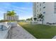 Community putting green with outdoor grills, seating area, and building views on a sunny day at 2910 W Barcelona St # 1902, Tampa, FL 33629
