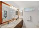 Bathroom featuring dual sinks, granite counters, and a large mirror at 294 Kentucky Ave, Crystal Beach, FL 34681