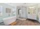 Bathroom featuring a modern soaking tub, glass shower, and sleek vanity with stylish fixtures and ample natural light at 294 Kentucky Ave, Crystal Beach, FL 34681