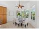 Bright dining room features neutral furnishings, a ceiling fan, and a large window with views of lush greenery at 294 Kentucky Ave, Crystal Beach, FL 34681