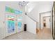 Bright and airy foyer with tiled floors and decorative front doors, leading to a staircase at 294 Kentucky Ave, Crystal Beach, FL 34681