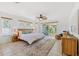 Spacious main bedroom features a patterned rug, ceiling fan, and sliding doors to a balcony at 294 Kentucky Ave, Crystal Beach, FL 34681