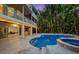 Private outdoor pool with a spa, covered patio, and lush tropical landscaping at 294 Kentucky Ave, Crystal Beach, FL 34681