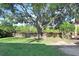 Scenic backyard featuring a large tree, swing, wooden fence, and water view at 29737 Fog Hollow Dr, Wesley Chapel, FL 33543