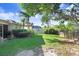 Lush backyard with green grass, mature trees, and a serene view of the adjacent pond at 29737 Fog Hollow Dr, Wesley Chapel, FL 33543