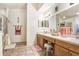 Bright bathroom with dual sinks, a vanity area, tile floors, and a glass-enclosed shower at 29737 Fog Hollow Dr, Wesley Chapel, FL 33543