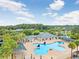 Aerial view of a unique clover-shaped community pool with ample seating and lush tropical landscaping at 29737 Fog Hollow Dr, Wesley Chapel, FL 33543