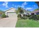 Well-maintained one story home with a two-car garage, manicured lawn, and mature landscaping at 29737 Fog Hollow Dr, Wesley Chapel, FL 33543