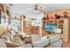 Inviting living room featuring a plush sectional sofa, hardwood floors, and an open-concept design into the kitchen area at 29737 Fog Hollow Dr, Wesley Chapel, FL 33543