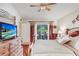 Beautiful main bedroom featuring a wood bed frame, dresser with TV, and sliding glass doors to the backyard at 29737 Fog Hollow Dr, Wesley Chapel, FL 33543