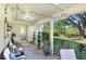Inviting screened-in patio with various potted plants, outdoor furniture and backyard view at 29737 Fog Hollow Dr, Wesley Chapel, FL 33543