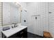 Sleek bathroom featuring a modern vanity, black fixtures, stand up shower and stylish black and white tile flooring at 30247 Fairway Dr, Wesley Chapel, FL 33543
