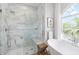 Bright bathroom featuring a glass shower, freestanding tub, and a view to the outdoors at 30247 Fairway Dr, Wesley Chapel, FL 33543