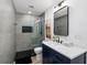 Modern bathroom with glass enclosed shower, sleek blue vanity, contrasting black and white accents, and unique wall decor at 30247 Fairway Dr, Wesley Chapel, FL 33543