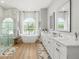 Bright bathroom with dual vanities, freestanding tub, glass shower, and a large window at 30247 Fairway Dr, Wesley Chapel, FL 33543