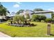 A lush lawn and attractive landscaping accentuate this home's curb appeal, enhanced by beautiful plants and an illuminated lamp post at 30247 Fairway Dr, Wesley Chapel, FL 33543