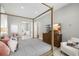 Bright main bedroom featuring a four-poster bed, ensuite bathroom and a serene atmosphere for relaxation at 30247 Fairway Dr, Wesley Chapel, FL 33543