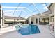 A beautiful screened in-ground pool provides a refreshing escape with a spa, dining area, and open backyard views at 30247 Fairway Dr, Wesley Chapel, FL 33543