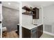 Modern wet bar area featuring sleek cabinetry, open shelves, mini-fridge and easy access to adjacent bathroom at 30247 Fairway Dr, Wesley Chapel, FL 33543