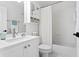 A clean, all-white bathroom features storage, a framed mirror, and a shower with a curtain at 3325 W Wallcraft Ave, Tampa, FL 33611