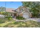 Charming two-story home with a well-manicured lawn, stone accents, a two-car garage, and a basketball hoop at 3325 W Wallcraft Ave, Tampa, FL 33611