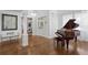 Elegant foyer with hardwood floors, a grand piano, and a decorative chandelier creating a welcoming entrance at 3325 W Wallcraft Ave, Tampa, FL 33611