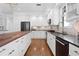 Modern kitchen featuring stainless steel appliances, granite counters, white cabinetry, and wood floors at 3325 W Wallcraft Ave, Tampa, FL 33611