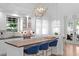 Bright kitchen featuring an island with bar seating, modern lighting, white cabinets, and high-end appliances at 3325 W Wallcraft Ave, Tampa, FL 33611