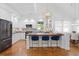 Modern kitchen with island seating, updated lighting, white cabinetry, and hardwood floors, perfect for entertaining guests at 3325 W Wallcraft Ave, Tampa, FL 33611
