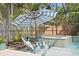 Relaxing pool with Adirondack chairs in the water and a waterfall spa, all enclosed by a screened lanai at 3325 W Wallcraft Ave, Tampa, FL 33611