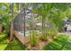 Exterior view of a screened-in pool surrounded by lush landscaping and a covered outdoor dining area at 3325 W Wallcraft Ave, Tampa, FL 33611