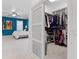 Spacious walk-in closet with ample shelving and hanging space, adjacent to a carpeted bedroom with a ceiling fan at 3325 W Wallcraft Ave, Tampa, FL 33611