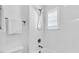 Modern bathroom featuring white tile shower, rainfall shower head, and a window with natural light at 4251 W Roland St, Tampa, FL 33609
