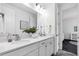 Bright bathroom with double sinks, quartz countertops, white shaker cabinets, and modern fixtures at 4251 W Roland St, Tampa, FL 33609