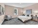 Bright bedroom featuring a cozy chair, plush gray carpeting, and a comfortable queen-sized bed at 4251 W Roland St, Tampa, FL 33609