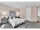 Relaxing bedroom with a queen-sized bed, gray carpeting, modern art and soft, neutral walls at 4251 W Roland St, Tampa, FL 33609