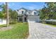 Charming two-story home with a manicured lawn and gray brick driveway at 4251 W Roland St, Tampa, FL 33609