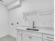 Bright laundry room with white cabinets, quartz countertops, and a utility sink at 4251 W Roland St, Tampa, FL 33609