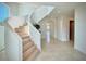 Bright foyer features a winding staircase, white walls, and light tile flooring, enhancing the home's elegant aesthetic at 4321 S Renellie Dr, Tampa, FL 33611