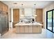Modern kitchen boasts a marble island, custom cabinets, stainless steel appliances, and stylish pendant lighting at 4321 S Renellie Dr, Tampa, FL 33611