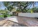 Home exterior with a driveway, large shade tree, lush green lawn, and a white privacy fence at 4926 Camellia S Way, St Petersburg, FL 33705